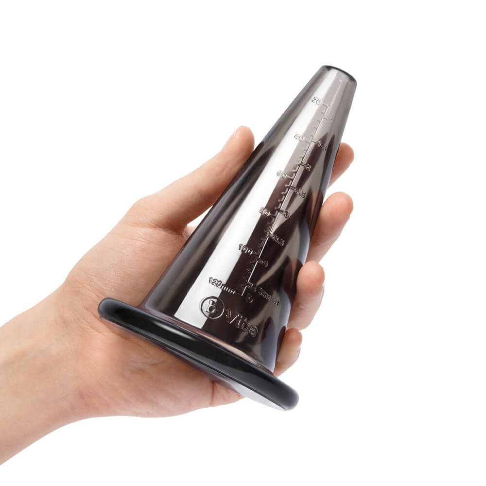 A person holds the hollow cone from the b-Vibe mASSter's Degree Anal Set. It is a very thick, shiny cone. The thickest diameter looks to match the diameter of the person's flat palm. | Kinkly Shop
