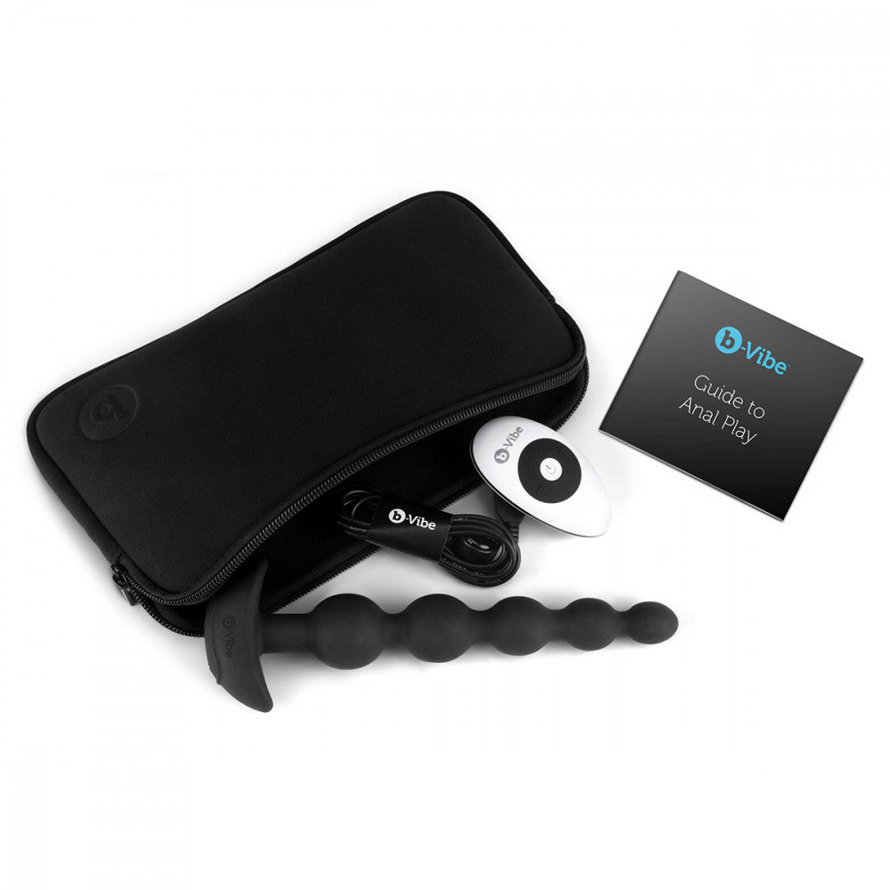 b-Vibe Cinco Remote Control Rechargeable Beads in a lay-flat image that shows the vibrating anal beads laying inside the storage pouch alongside the charging able, the remote control vibrating anal beads remote, and the Guide to Anal Play information booklet. | Kinkly Shop
