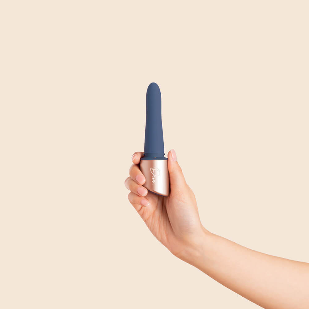 A person's hand holds the base of the Deia The Couple interchangeable tip vibrator without the g-spot sleeve. The insertable portion of the vibrator looks smaller in width than the person's two fingers. | Kinkly Shop