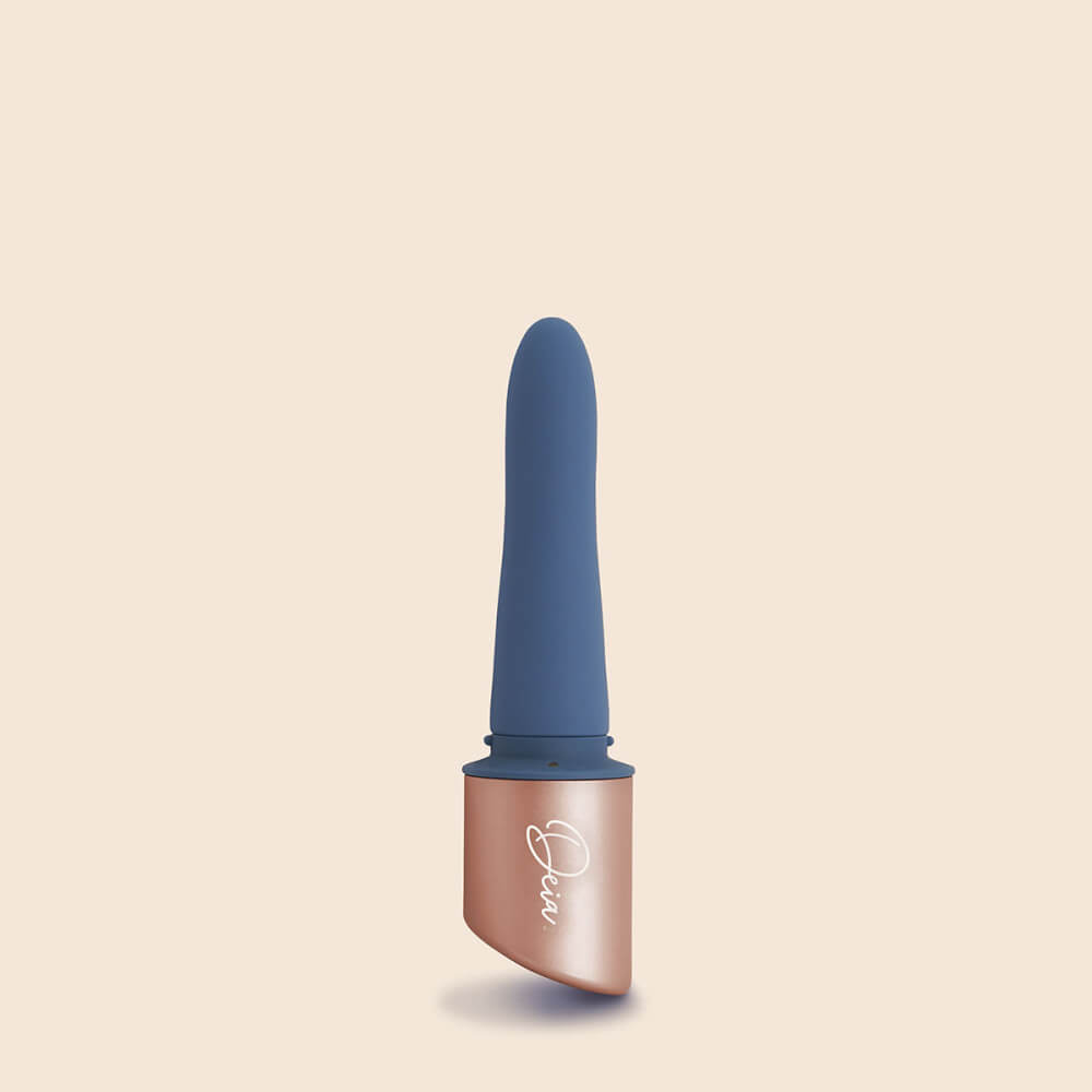 Close-up of the Deia The Couple interchangeable tip vibrator up against a brown background. The snap-in system for the g-spot sleeve can be seen up against the base of the Deia The Couple | Kinkly Shop