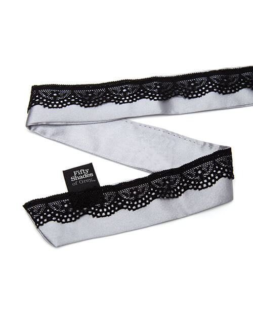 Close-up of the tie for th "Play Nice" Satin Collar with Nipple Clamps. There is a sewn-in tag that says "Fifty Shades of Grey". | Kinkly Shop