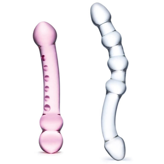Both dildos included in the GLAS Double Pleasure Set sitting out in front of a white background. The pink dildo is slightly thicker and shorter than the clear dildo. Both are double-ended. | Kinkly Shop