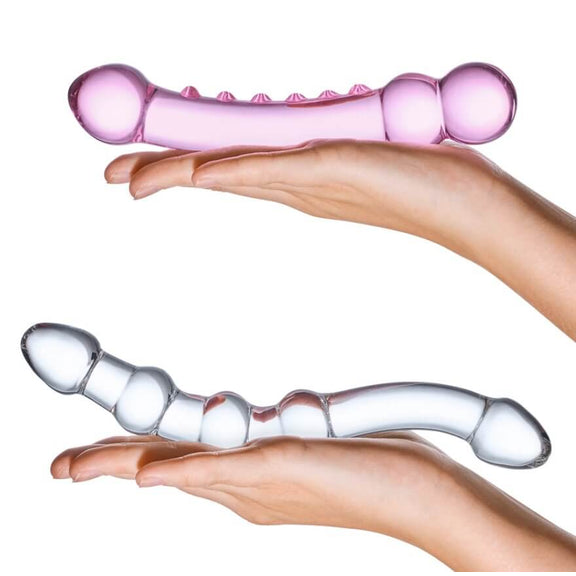 Two outstretched, flat hands hold the two dildos in the GLAS Double Pleasure Set kit. This side-by-side comparison showcases the different thickness, length, and angles of the two included dildos. | Kinkly Shop