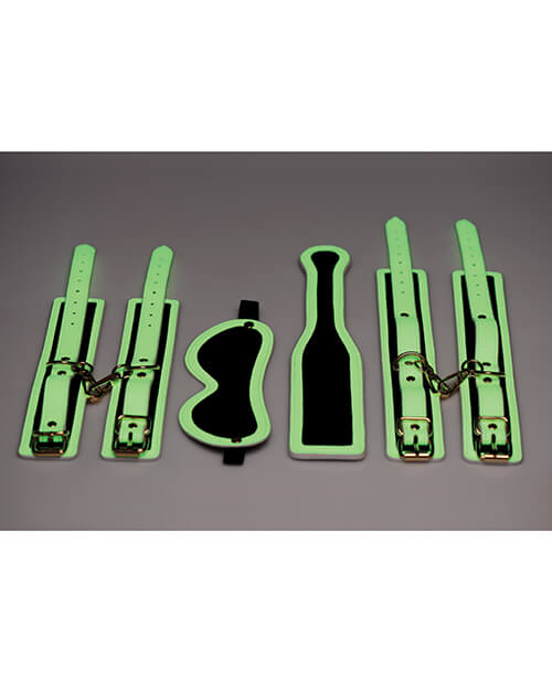 All of the pieces of the Master Series Kink in the Dark Set laid flat in a semi-dark area. All of the cuffs are laid flat. | Kinkly Shop