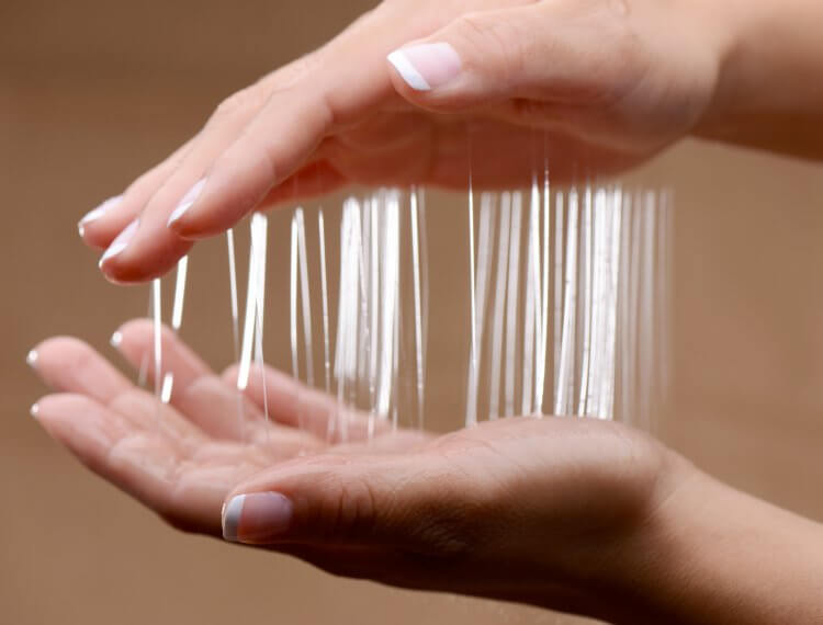 Two hands covered in Nuru Couple's Body Massage Gel are slowly pulling apart from one another. This leaves strings of the slick gel visible between the two hands to showcase the gooey-ness of the Nuru Couple's Body Massage Gel. | Kinkly Shop