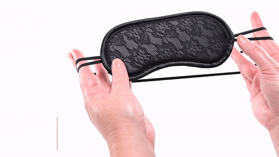 GIF of a person handling the Sportsheets Lace Blindfold. It shows how stretchy the head strap is. The text says "Double straps provide security and comfort." | Kinkly Shop