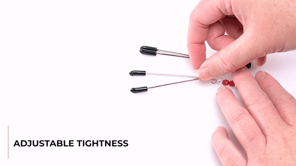 GIF showing someone handling the Sportsheets Ruby Black Nipple Clamps. The GIF shows the Adjustable Tightness through the rings on the shafts of the nipple clamps. The text says "Rings Slide Down: For Snug-As-You-Like Sensations". | Kinkly Shop