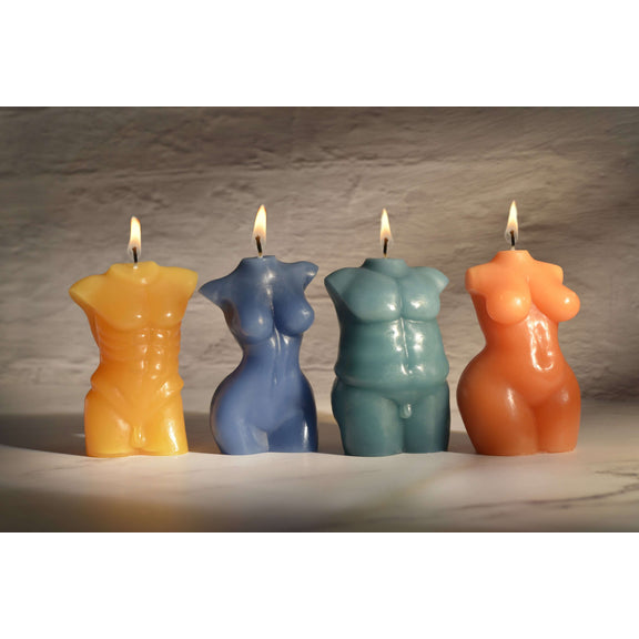 All of the four Sportsheets Torso Form Wax Play Candles sitting next to one another on top of a marbled surface. There's dark, moody lighting, and all of the candles are lit. This showcases all of the sculpted details of each candle. | Kinkly Shop