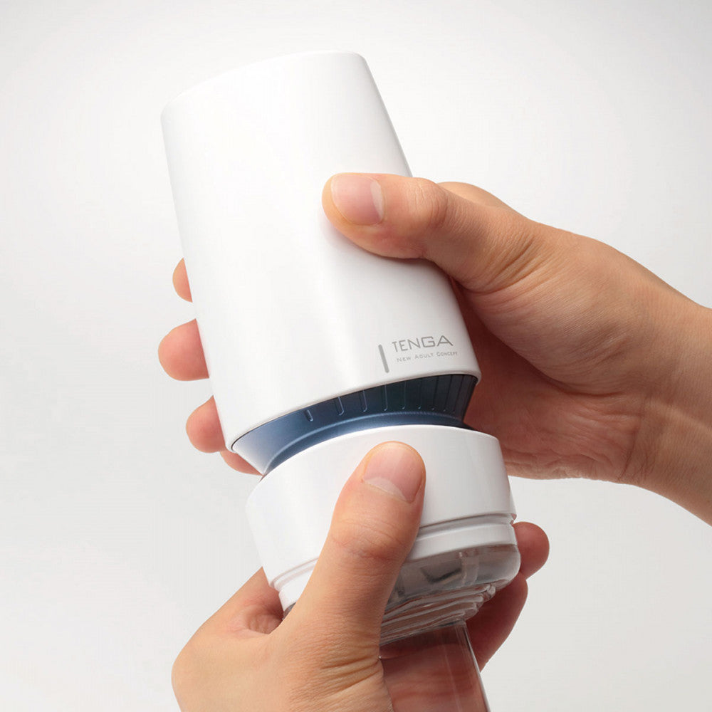 Two hands hold the Tenga Aero Cobalt while a glass cylinder is inserted. This shows how easy it is to change the suction settings mid-use by just adding a second hand. | Kinkly Shop