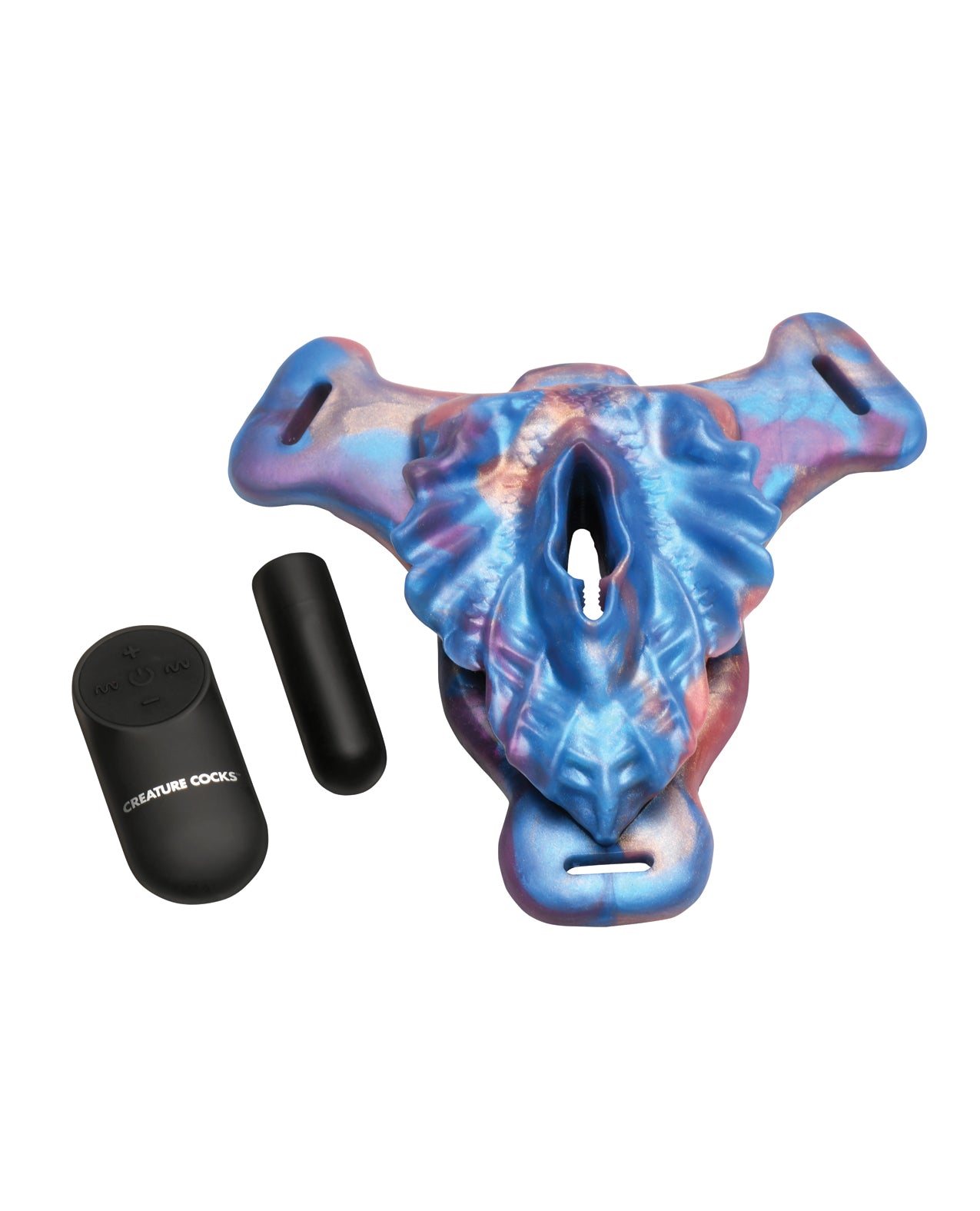 The Creature Cocks Siren Snatch Strap-On unfastened from the strap-on harness sitting next to the included bullet vibrator and the wireless remote control. | Kinkly