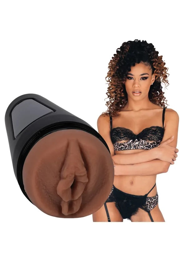 Scarlit Scandal is wearing lingerie and staring at the camera. The Main Squeeze - Scarlit Scandal stroker is shown nearby, next to the porn star. | Kinkly Shop