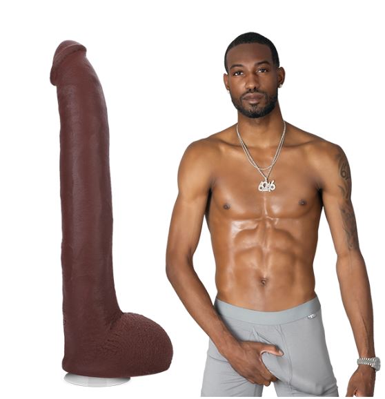 A shirtless Hollywood Cash stands while looking at the camera, grabbing a bulge in his boxer briefs. The Signature Cocks - Hollywood Cash dildo is shown next to him. | Kinkly Shop