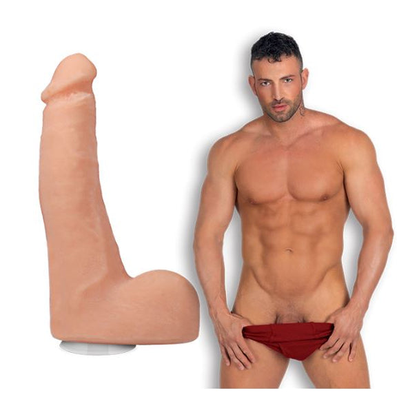 Maximo Garcia in front of a plain white background, pulling down his brief underwear while looking into the camera. The Signature Cocks - Maximo Garcia dildo is shown next to him, lifecast from the porn star. | Kinkly Shop