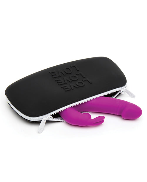 The Love Medium Silicone Storage Bag lays on its side. A full-sized rabbit vibrator is spilling out of it. The vibrator is big and it barely fits into the bag. | Kinkly Shop