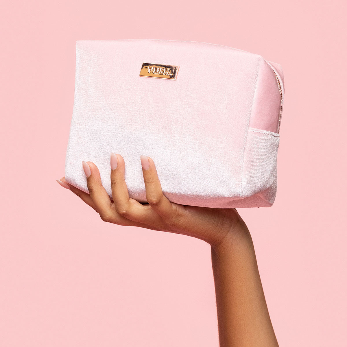 A hand holds the VUSH Making Moves Soft Storage Case in its open palm. The bag is a soft, pastel pink and looks very soft and plushy. | Kinkly Shop