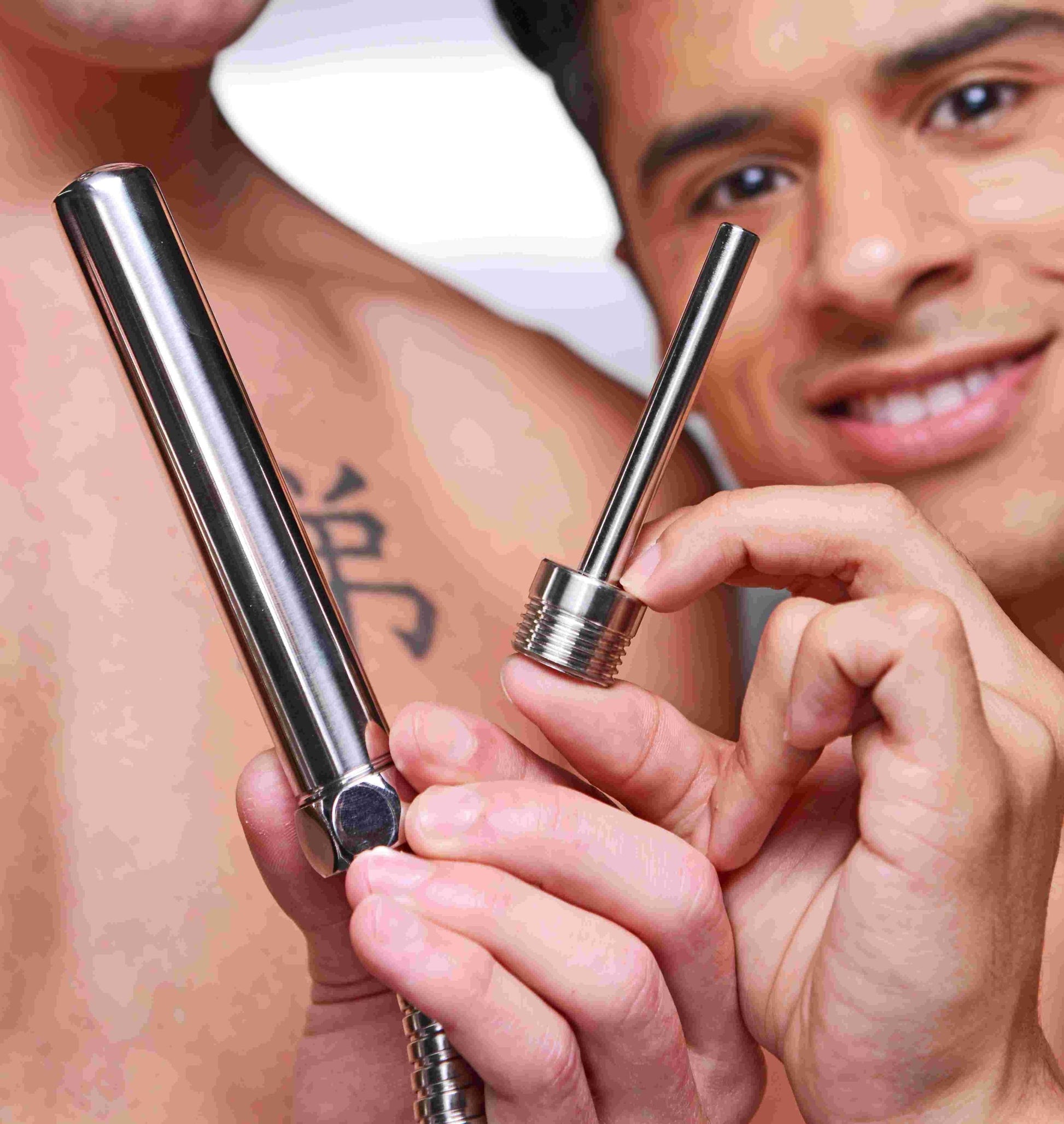 Two people are holding up the two included CleanStream Beginner Shower Enema Set nozzles up close against the camera to showcase their different sizes. | Kinkly Shop