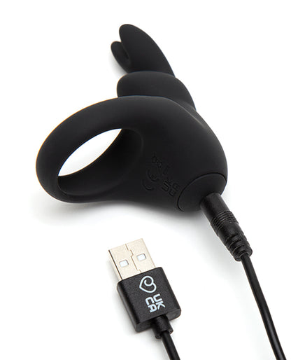The Happy Rabbit Rechargeable Cock Ring with a close-up on the base of the rabbit vibrator as the charging cable is plugged into the base. The other end of the charging cable has a USB plug. | Kinkly Shop