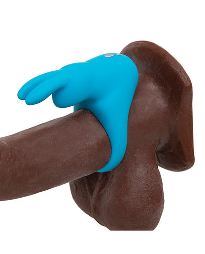 The Happy Rabbit Rechargeable Cock Ring in Blue wrapped around the base of a dildo, showcasing how the rabbit and its rabbit ear clitoral arms will surround the clit. | Kinkly Shop