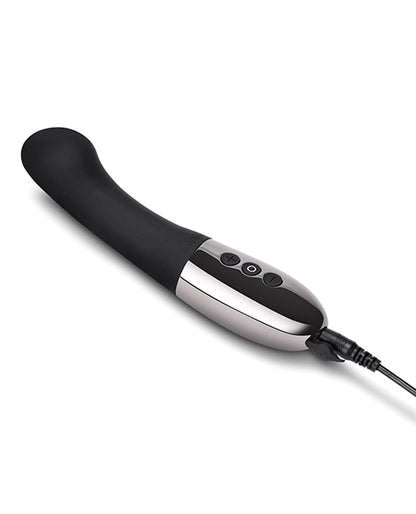 The Le Wand Gee vibrator in black plugged into the charging cable. There's a charging cable port door open at the base of the vibrator | Kinkly Shop