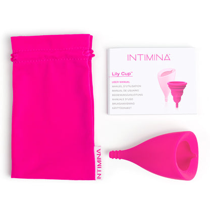 The Intimina Lily Cup B shown with everything it comes with including the drawstring bag and the instruction booklet. | Kinkly shop