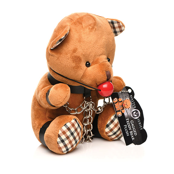 Side angle of the Master Series Gagged Teddy Bear. The teddy bear is wearing wrist cuffs, ankle cuffs, and a collar. | Kinkly Shop