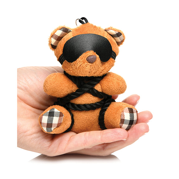 The Master Series Bound Teddy Bear Keychain sitting in someone's palm. It's small and comfortably fits in their palm. | KInkly Shop