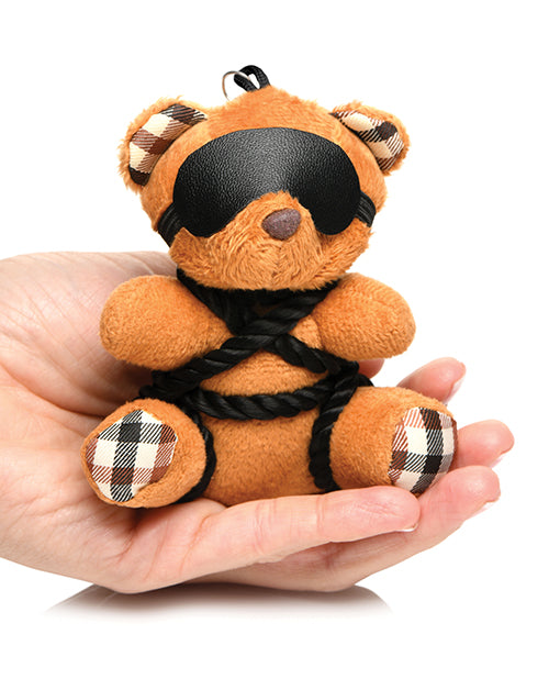 The Master Series Bound Teddy Bear Keychain sitting in someone's palm. It's small and comfortably fits in their palm. | KInkly Shop