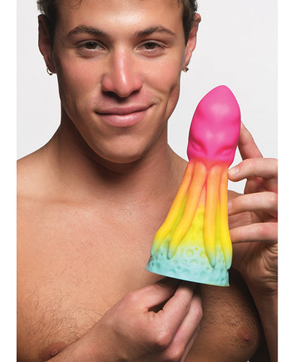 A person holds the Creature Cocks King Kraken between their hands. It looks like average length but very VERY thick near the base. It has a cute rainbow ombre color. | Kinkly Shop
