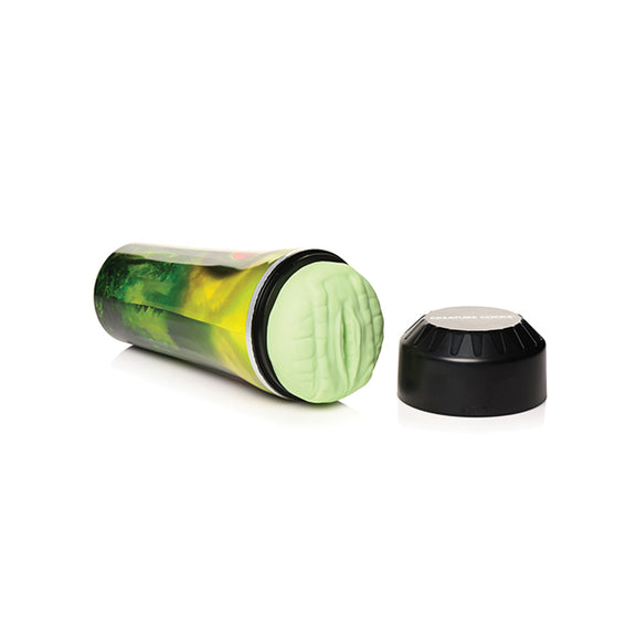 The Creature Cocks Raptor Stroker lays on its side with the black cap removed from the top of the stroker. This showcases the unique, 3D texture of the reptile orifice. | Kinkly Shop