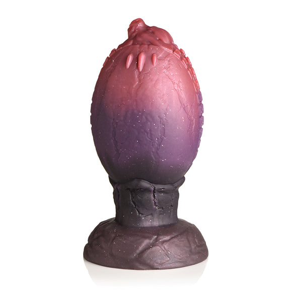 Backside of the Creature Cocks Dragon Hatch showcasing the little dragon's head poking out of the egg as their claws "go through" the flat surface of the egg on this side. | Kinkly Shop