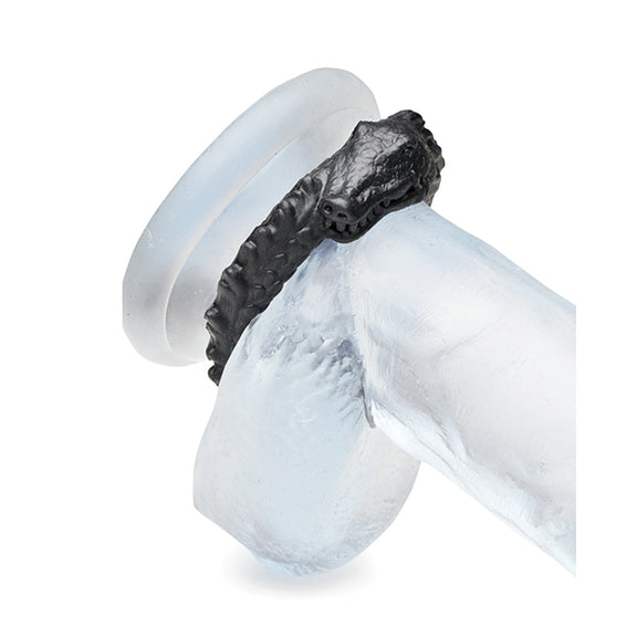 The Creature Cocks Caiman shown wrapped around the base of a clear dildo. It's under the shaft and the testicles, flush up against the fake-body of the dildo. | Kinkly Shop