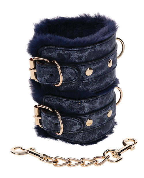 Close-up on the faux leather and faux fur materials on the Sportsheets Cougar Fur Wrist Cuffs. The faux leather has a textured grain to it. The matching gold connector chain is fully detachable from both cuffs. | Kinkly Shop