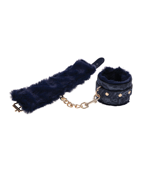 One Sportsheets Cougar Fur Wrist Cuffs is laid out flat while another is curled up into a circle next to it. The gold connector chain connects them both. The faux fur interior looks extremely plushy and soft. | Kinkly Shop