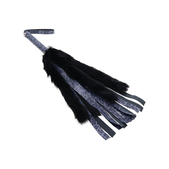 Close-up on the tails of the Sportsheets Cougar Faux Fur Flogger showcase how much longer the leather tails are than the faux fur. The leather tails are much longer than the black faux fur ones. | Kinkly Shop
