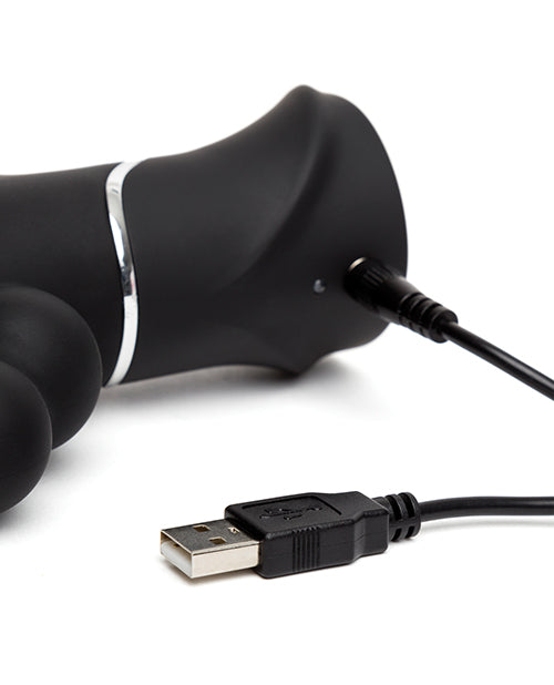 Close-up of the charging cable for the Happy Rabbit Triple Curve plugged into the charging port. It looks like a pin-style charger that has to penetrate the toy itself to charge. | Kinkly Shop