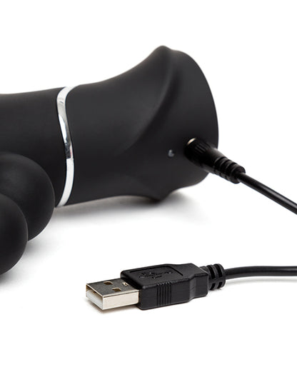 Close-up of the charging cable for the Happy Rabbit Triple Curve plugged into the charging port. It looks like a pin-style charger that has to penetrate the toy itself to charge. | Kinkly Shop