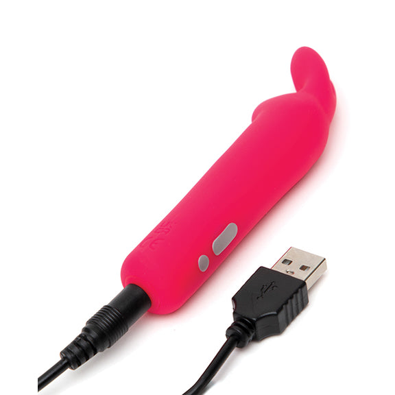 The Happy Rabbit Rabbit Ears plugged into the charger. The charging port is at the base of the toy with a pin-style charger that needs to be plugged inside of the toy for charging. | Kinkly Shop