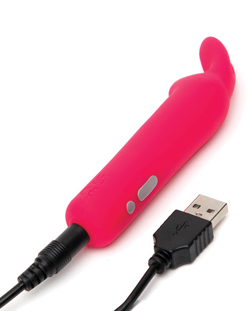 The Happy Rabbit Rabbit Ears plugged into the charger. The charging port is at the base of the toy with a pin-style charger that needs to be plugged inside of the toy for charging. | Kinkly Shop