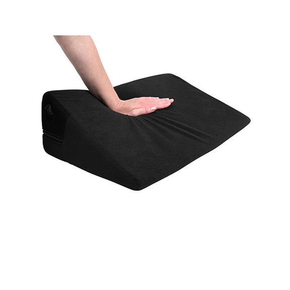A hand presses firmly down on the top of the Sportsheets Pivot Positioner, showcasing how firm the shape is. It compresses more than competitor shapes, but it still offers quite a bit of upwards boost despite the applied weight. | Kinkly Shop