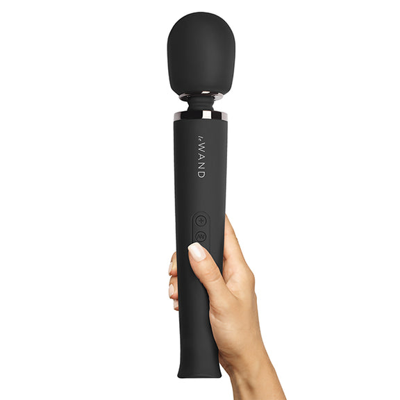 A hand holds the Le Wand Rechargeable Wand in Black against a plain white background | Kinkly Shop
