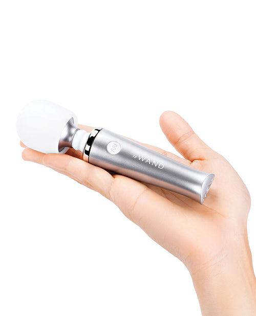 A palm is outstretched with the Le Wand Mini wand sitting in it. The wand isn't even as long as the person's outstretched hand. It is very small. | Kinkly Shop