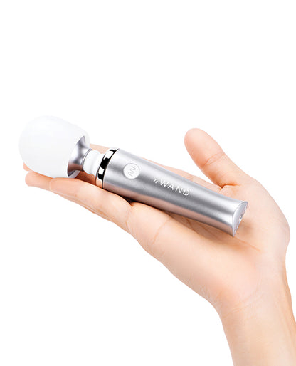 A palm is outstretched with the Le Wand Mini wand sitting in it. The wand isn't even as long as the person's outstretched hand. It is very small. | Kinkly Shop