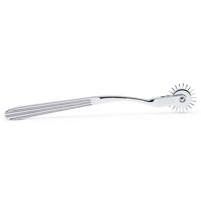 The Fifty Shades "Adrenaline Spikes" Pinwheel lays on a flat surface. The slotted texture of the handle to make it easier to grip is very visible here. | Kinkly Shop