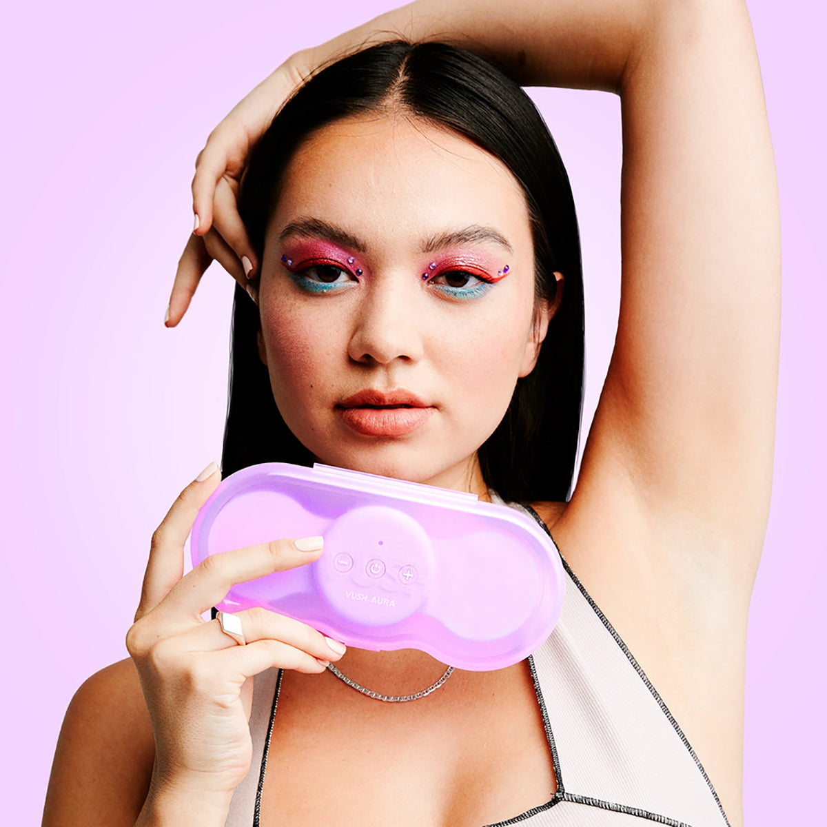 A person holds the VUSH Aura Wireless TENS Device inside of its travel case in front of their face. | Kinkly Shop