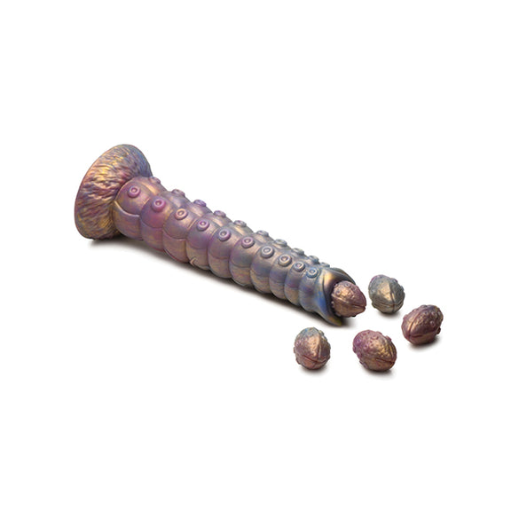 The Creature Cocks Deep Invader Ovipositor laying on a flat surface with the matching silicone eggs shown being "laid" out the tip of the dildo | Kinkly Shop