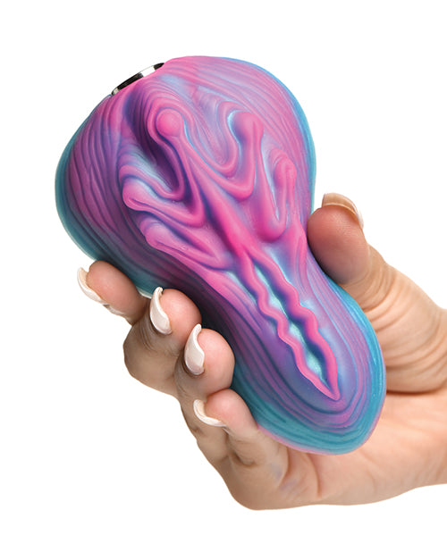 A person holds the Creature Cocks Vulvaron Remote-Control Vibrating Grinder in their hand. The toy is noticeably larger than their hand for easier sitting on top of it. | Kinkly Shop