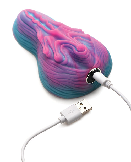 The Creature Cocks Vulvaron Remote-Control Vibrating Grinder shown plugged into the charger. | Kinkly Shop
