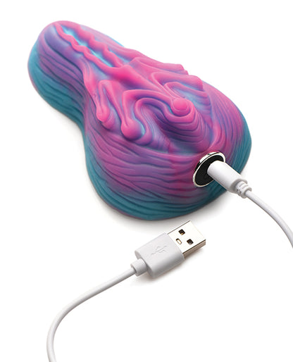 The Creature Cocks Vulvaron Remote-Control Vibrating Grinder shown plugged into the charger. | Kinkly Shop