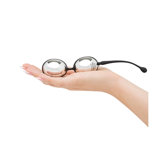 A palm is held out flat. The Inner Goddess Jiggle Balls rests in their hand. The balls are oval-shaped and look long with an average-penis thickness. | Kinkly Shop