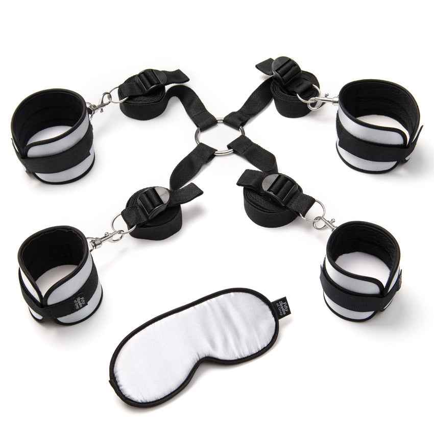 Everything included with the Fifty Shades of Grey Bed Restraint Kit. There are four cuffs, the under-the-bed-restraint frame, and a matching silver blindfold. | Kinkly Shop